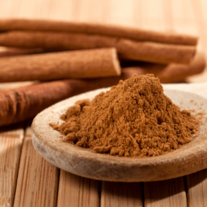 Cinnamon sticks and cinnamon powder in a bowl.